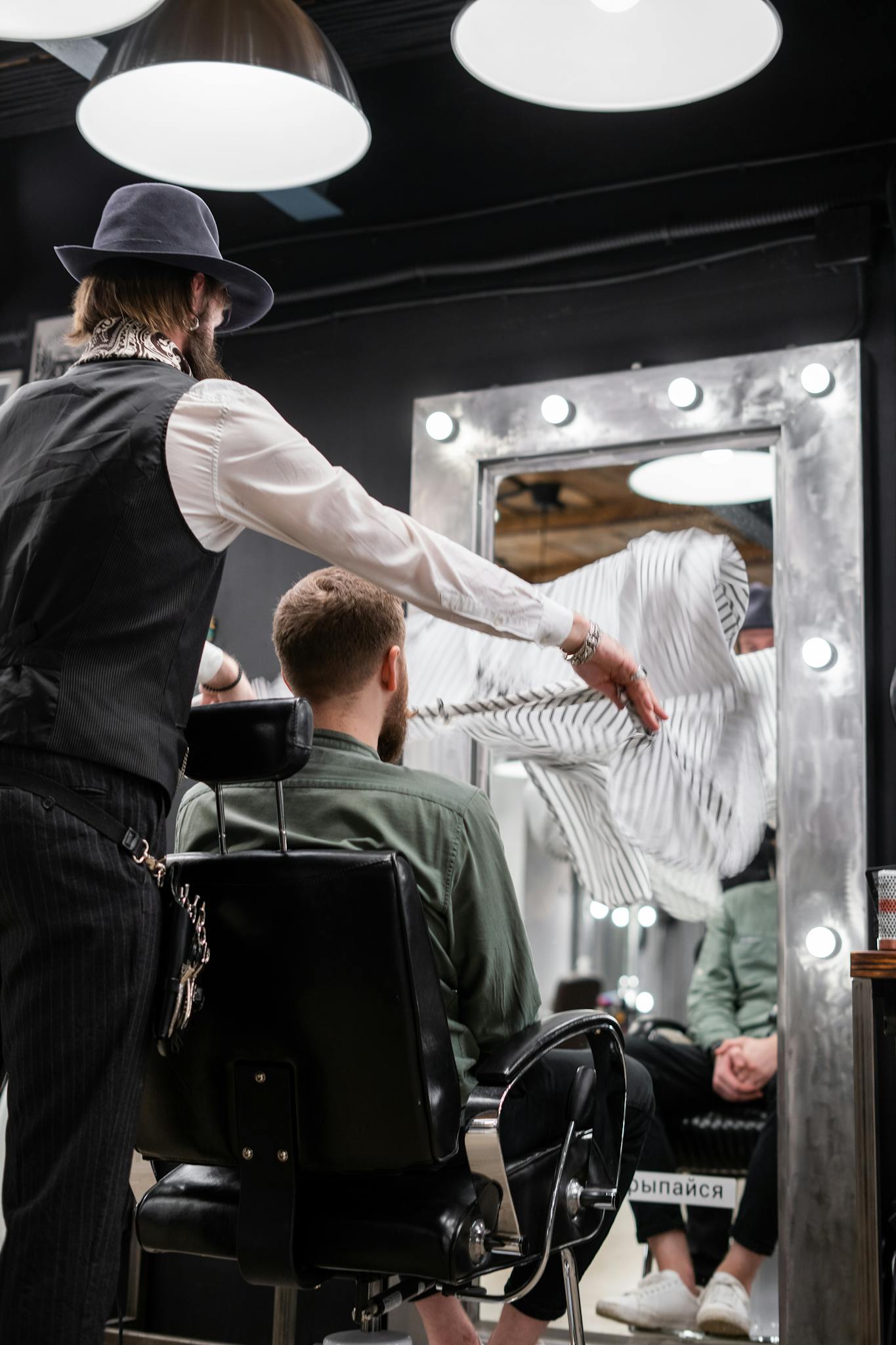 A barber engages in a stylish haircut for a customer in a modern barbershop.