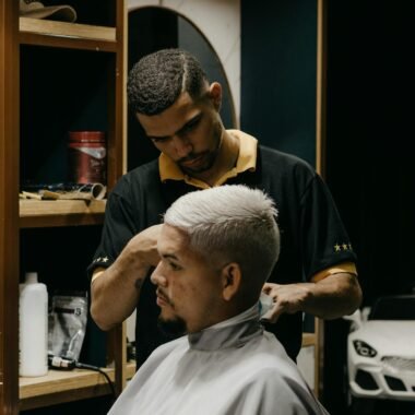 Barber styling a client's hair in a modern barbershop with focus on customer service.