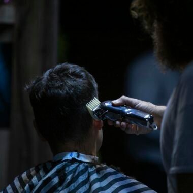 Barber using electric clipper for a precise haircut in a barber shop.