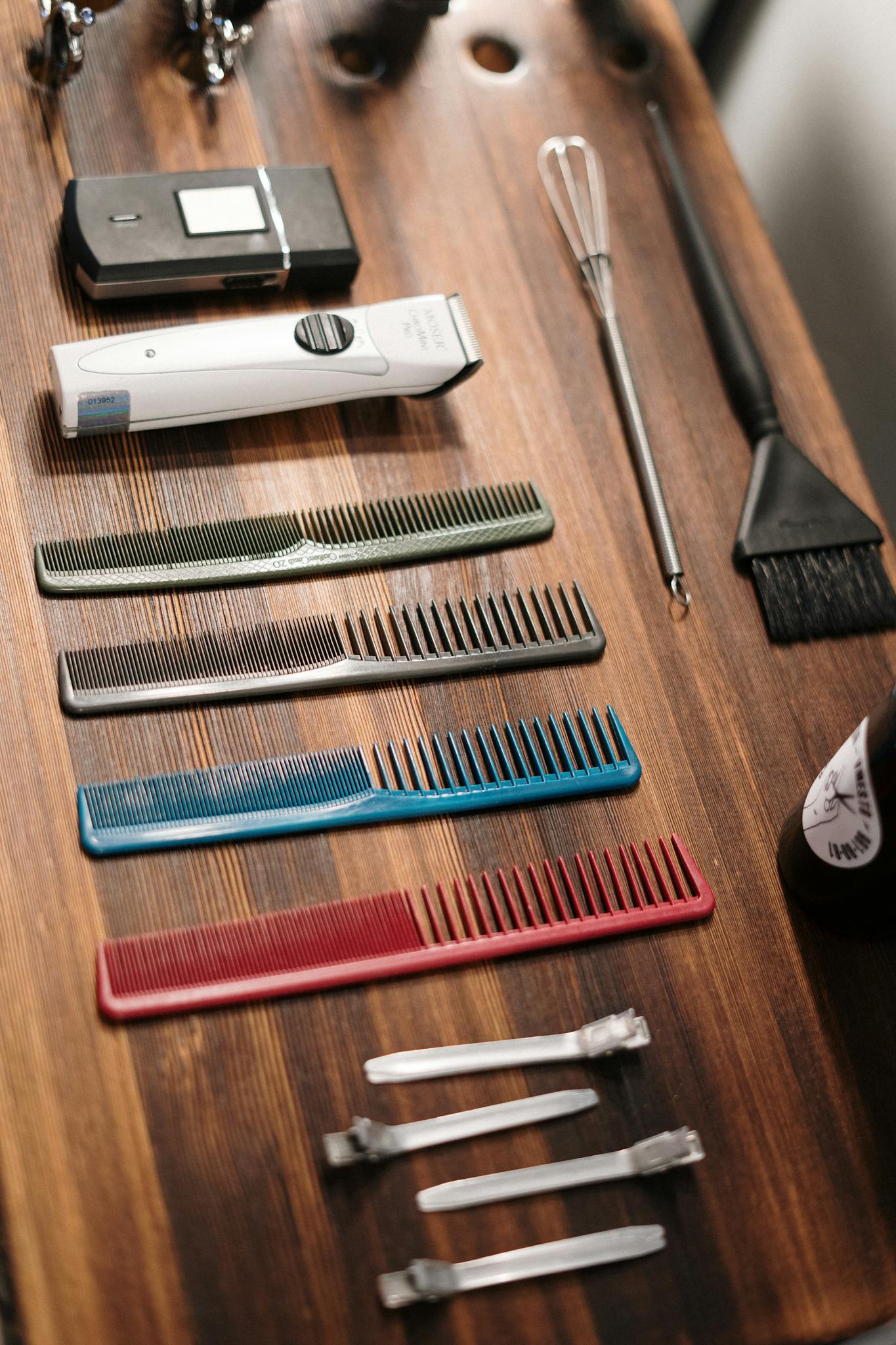 Organized collection of barber tools on a wooden table, ready for grooming.